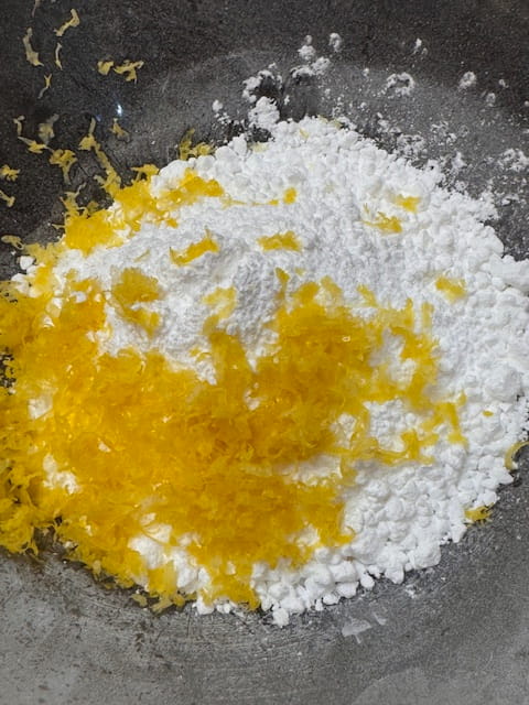 place lemon peel, powdered sugar in bowl