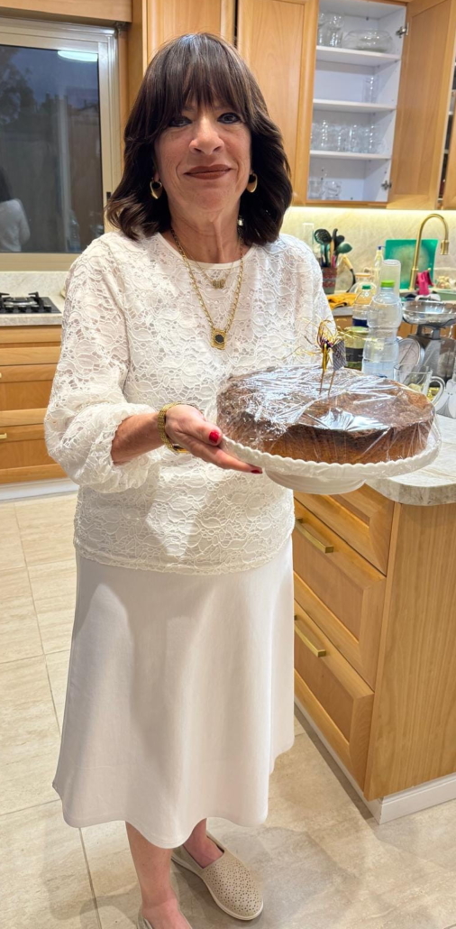 dressed in white, sour cream crumb cake in hand